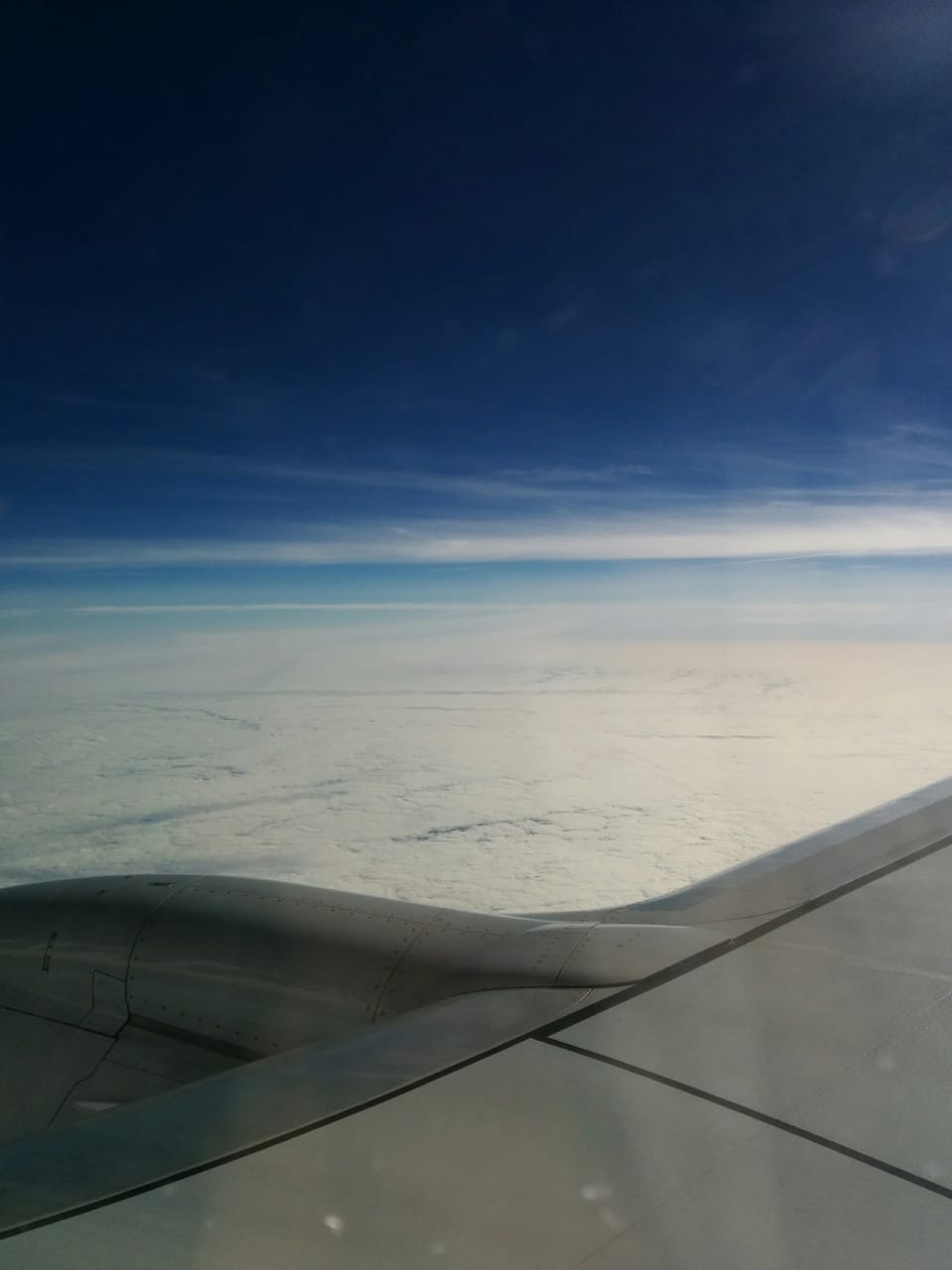 A photo of the warm and fluffy clouds from inside an airplane