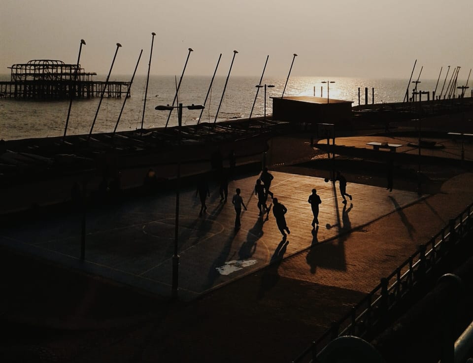 A photograph of people playing basketball on Brighton Beach