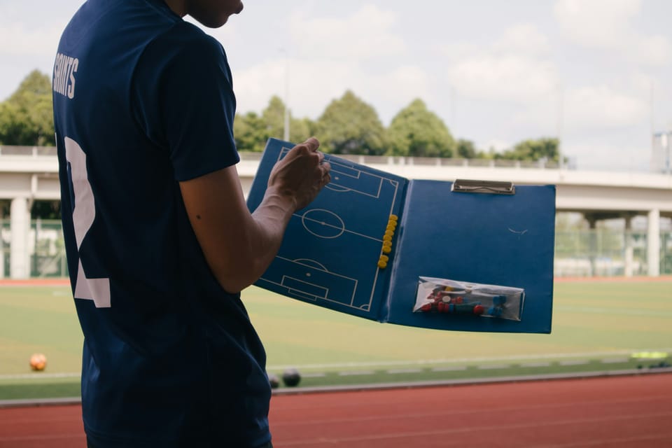 Photo of a football coach mapping out a plan for a game