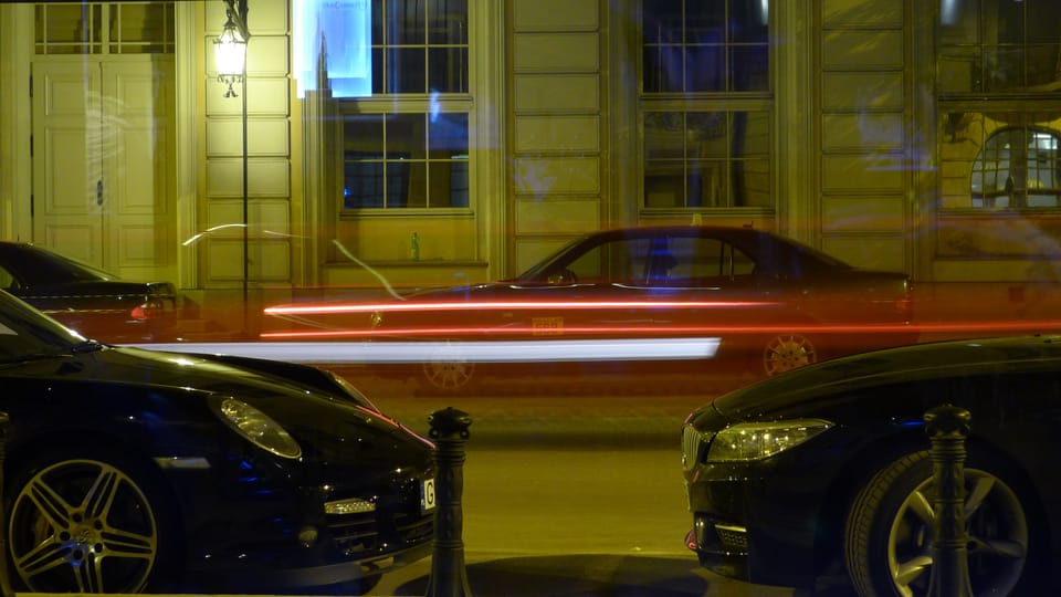 An image of a car going past a window leaving a streak of colour due to being shot on a slow shutter speed